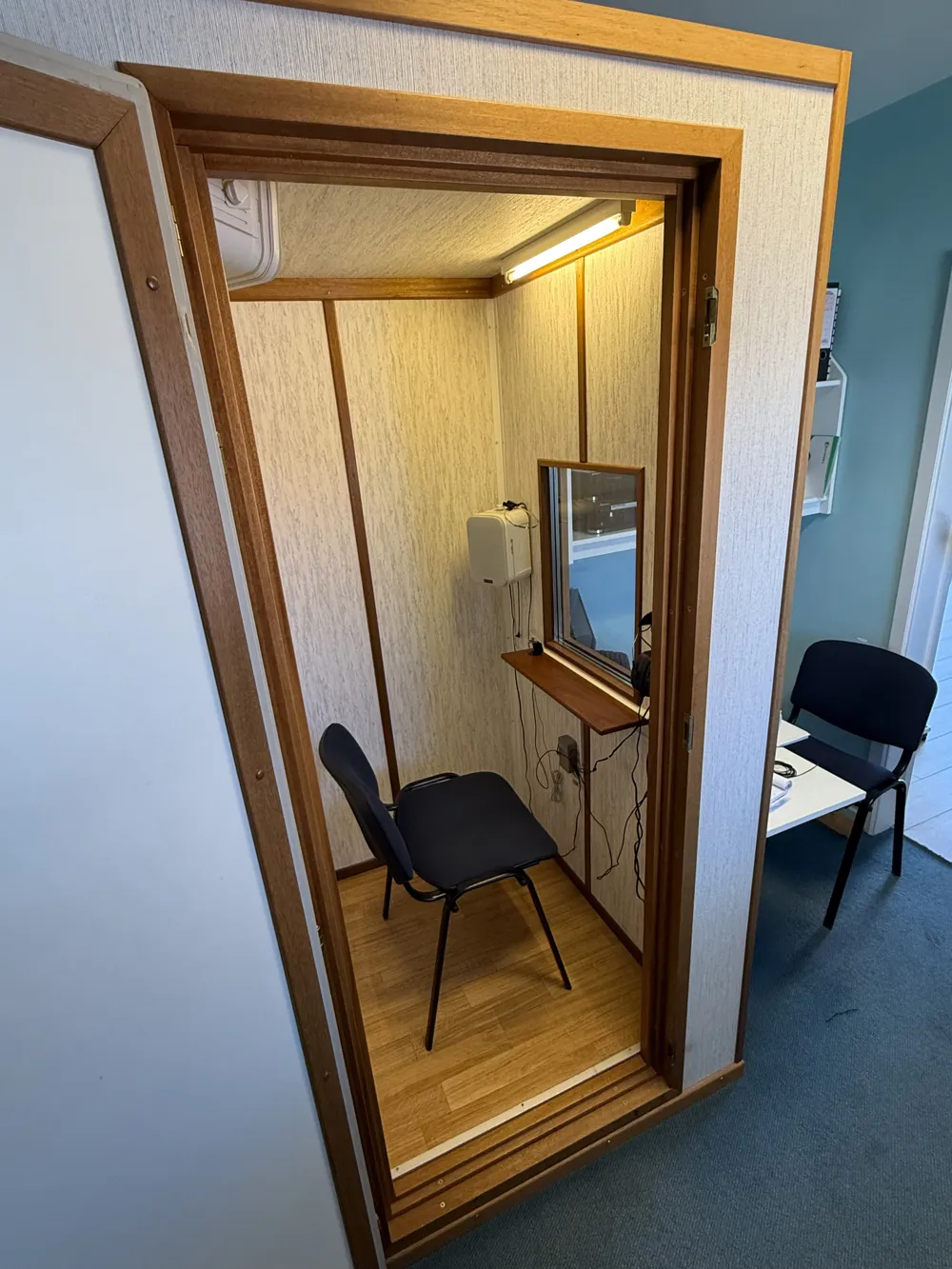 Soundproof audiometry booth with a chair