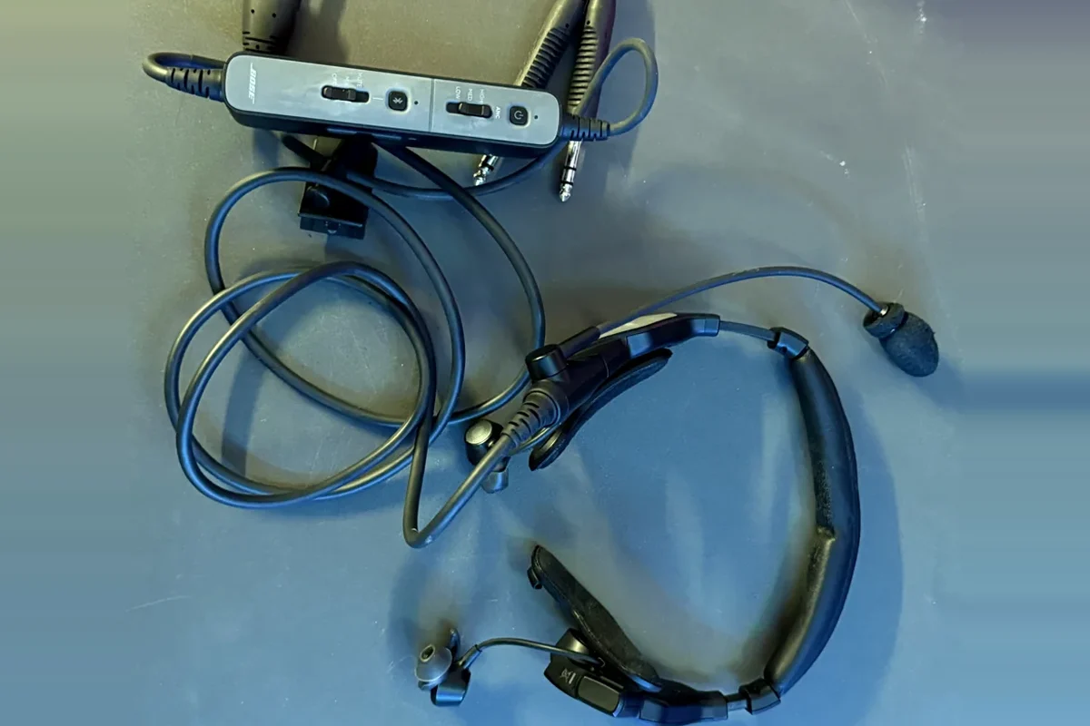 Bose ProFlight Series 2 laid flat: control module with the three noise reduction levels, plugs, boom mic, in-ear tips and thin, lightly padded neckband (personal photo)